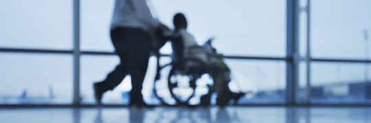 A medical professional pushing a patient in a wheelchair at the VA.