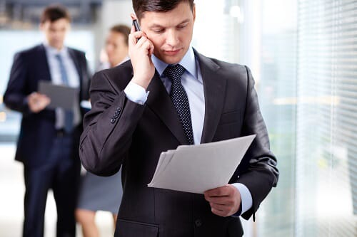 a man with security clearance is the phone while reviewing documents